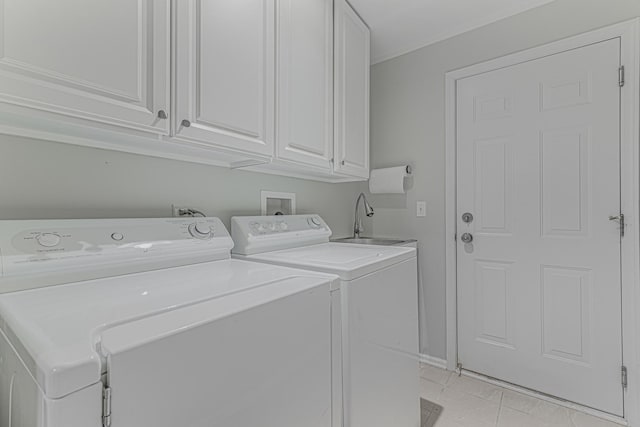 washroom featuring independent washer and dryer and cabinet space