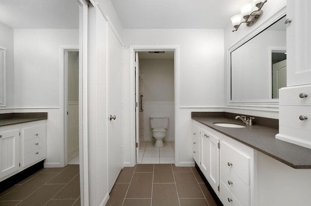 2700 E Bel Aire Dr Unit 304, Arlington Heights, IL 60004 - bathroom featuring tile patterned floors, vanity, toilet, and wainscoting