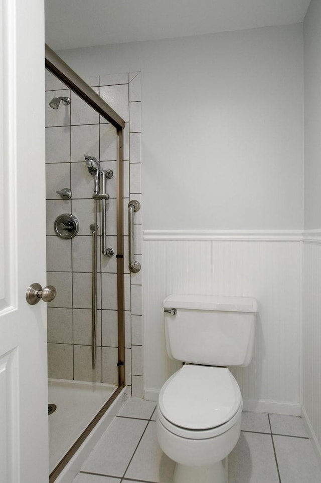 2700 E Bel Aire Dr Unit 304, Arlington Heights, IL 60004 - bathroom with tile patterned floors, a shower stall, a wainscoted wall, and toilet