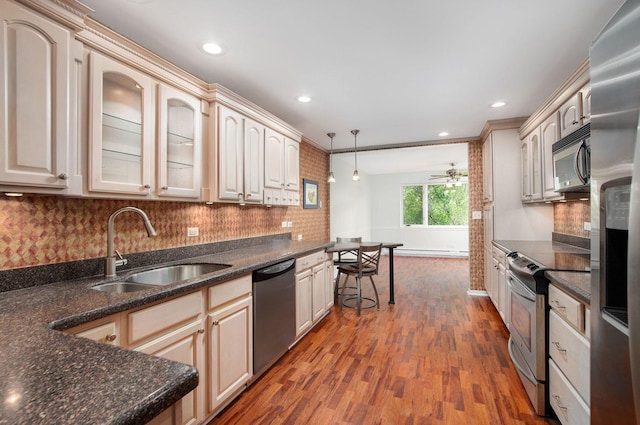 2700 E Bel Aire Dr Unit 304, Arlington Heights, IL 60004 - kitchen featuring stainless steel appliances, a sink, dark wood-style floors, cream cabinetry, and decorative backsplash
