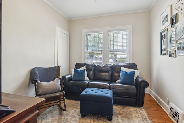 living area with wood finished floors, crown molding, and baseboards