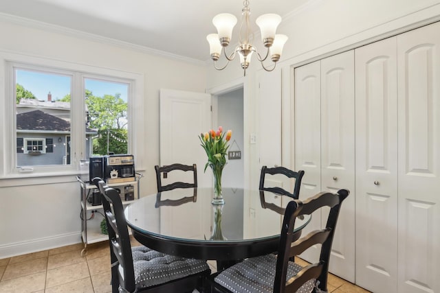 dining area with a chandelier, ornamental molding, baseboards, and light tile patterned floors