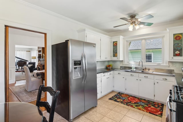 kitchen with stainless steel fridge with ice dispenser, a sink, stainless steel counters, white cabinetry, and a ceiling fan