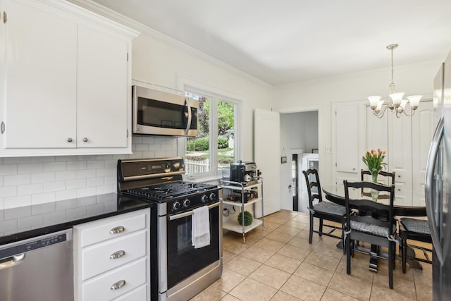 kitchen featuring stainless steel appliances, dark countertops, a chandelier, backsplash, and crown molding
