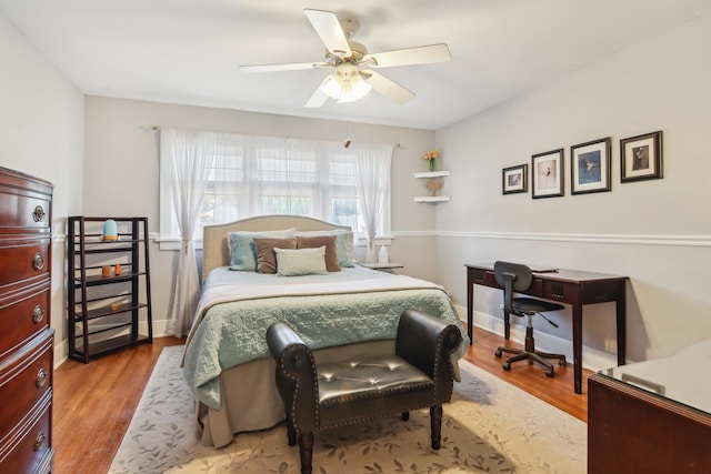 bedroom with wood finished floors, ceiling fan, and baseboards