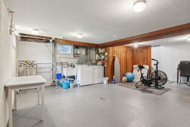 below grade area featuring washing machine and clothes dryer and wooden walls