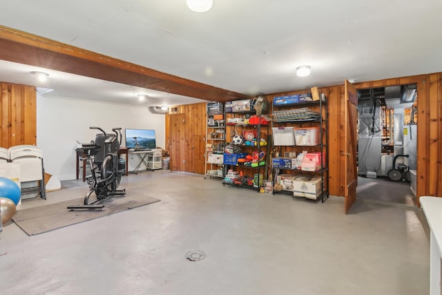 finished below grade area featuring wood walls and heating unit