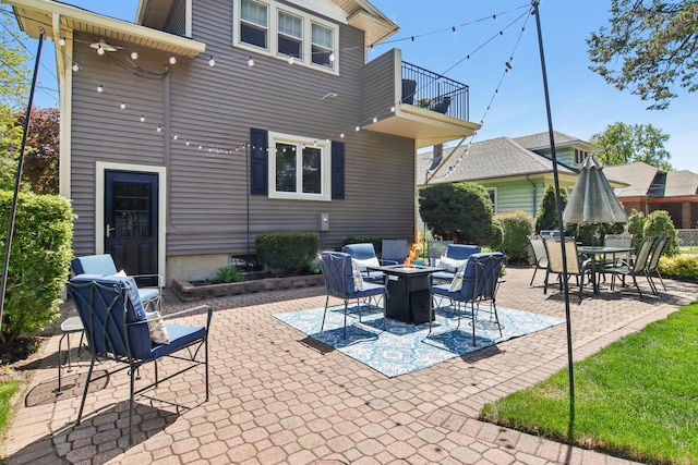 view of patio / terrace featuring a balcony, a fire pit, and outdoor dining space