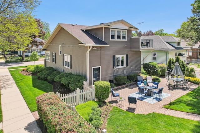 back of house with a patio area and a shingled roof