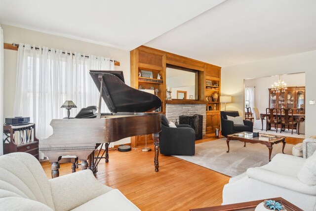 living area with a chandelier, wood finished floors, and a fireplace
