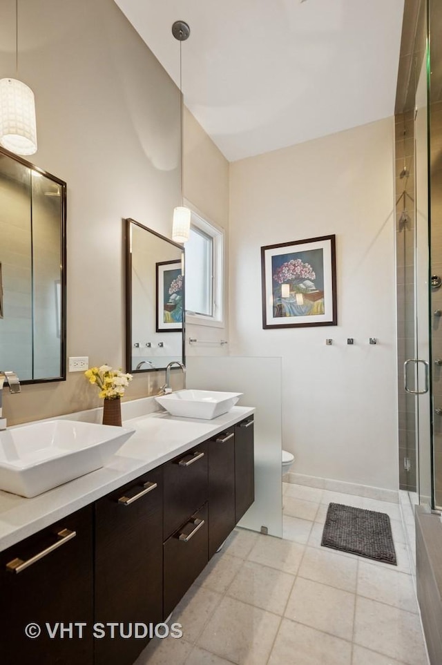 2116 W Barry Ave Unit 3, Chicago, IL 60618 - bathroom featuring double vanity, a shower stall, tile patterned flooring, and toilet