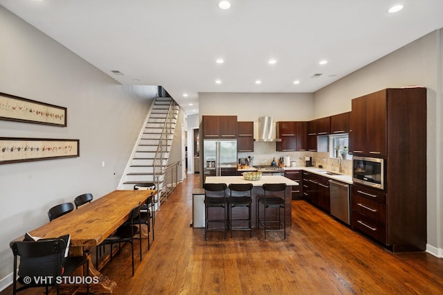 2116 W Barry Ave Unit 3, Chicago, IL 60618 - kitchen featuring stainless steel appliances, wall chimney exhaust hood, a center island, a sink, and light countertops