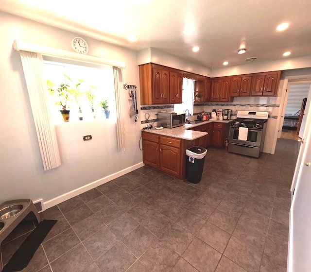 6209 N Nagle Ave, Chicago, IL 60646 - kitchen featuring appliances with stainless steel finishes, a sink, healthy amount of natural light, recessed lighting, and baseboards