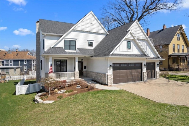 5233 Carpenter St, Downers Grove, IL 60515 - view of front facade featuring covered porch, a chimney, decorative driveway, board and batten siding, and stone siding