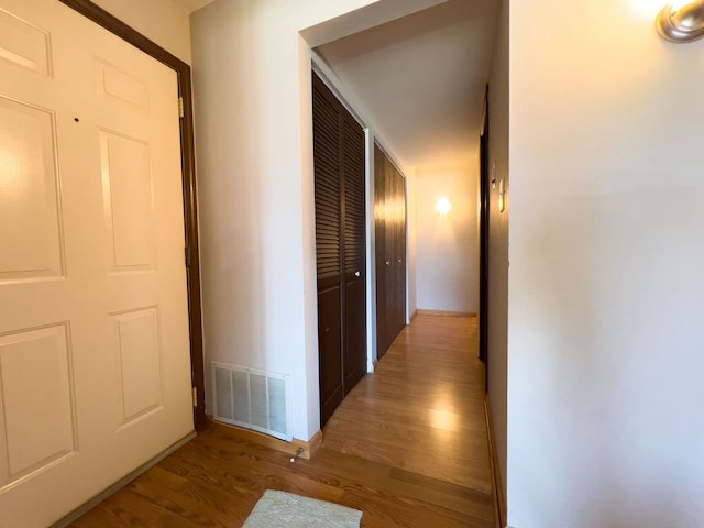 hall with wood finished floors and baseboards