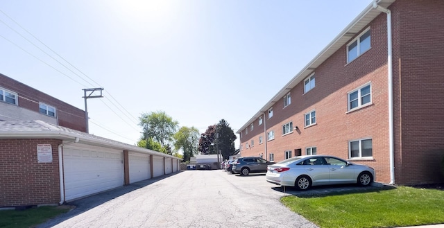 view of asphalt road with community garages