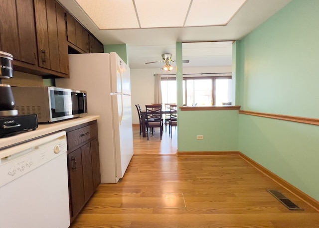 kitchen with white dishwasher, stainless steel microwave, a ceiling fan, dark brown cabinets, and light wood-style flooring