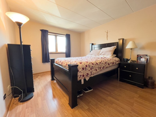bedroom with light wood finished floors and baseboards