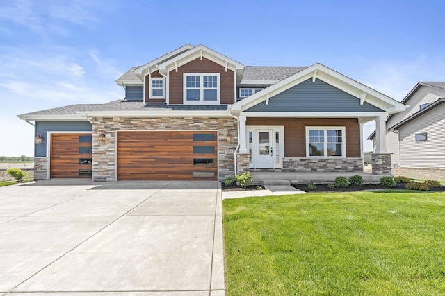 craftsman-style house featuring stone siding, a front yard, driveway, a porch, and a garage