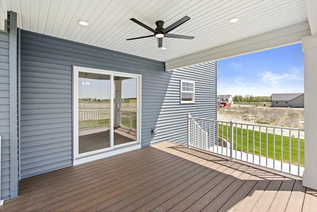 wooden deck featuring ceiling fan and a yard