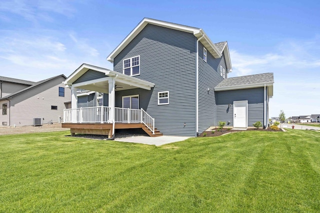 back of house with central AC unit, a lawn, and a ceiling fan