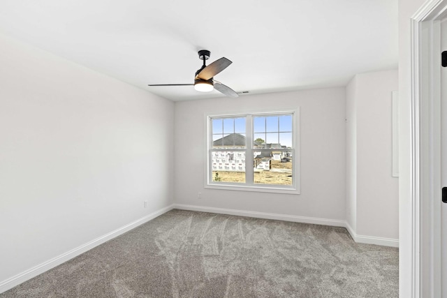 carpeted spare room with baseboards and ceiling fan