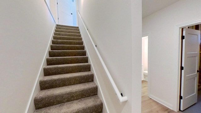 stairway featuring wood finished floors and baseboards