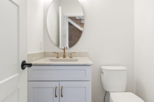 half bathroom featuring vanity and toilet