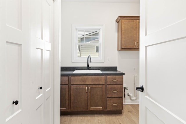 laundry area with a sink and light wood-type flooring