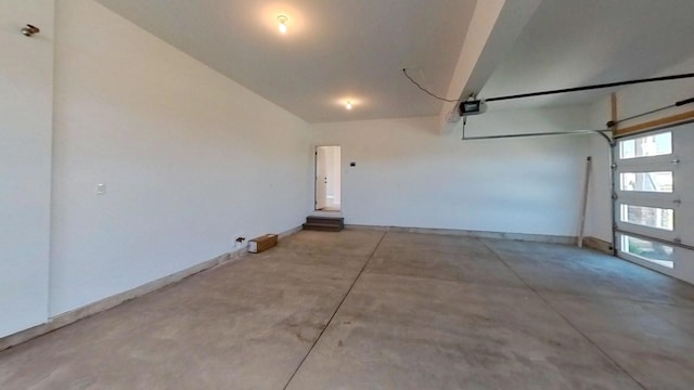 garage with a garage door opener and baseboards