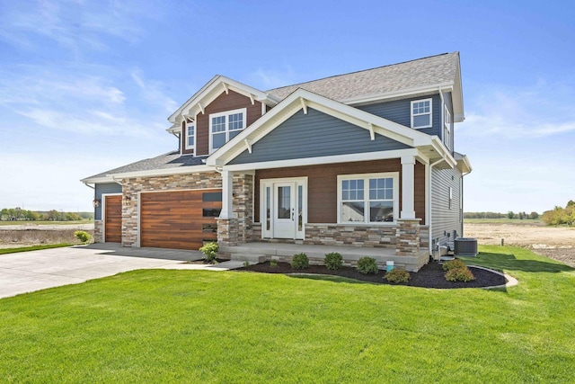 craftsman-style home featuring driveway, covered porch, a front lawn, stone siding, and a garage