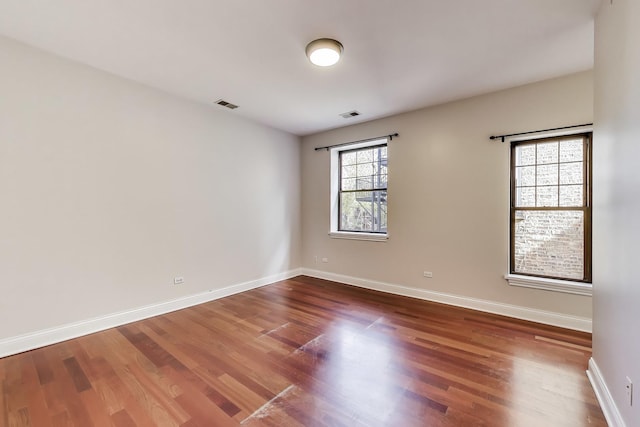 unfurnished room with wood finished floors and baseboards