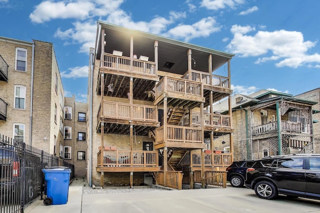 view of building exterior featuring fence and stairway