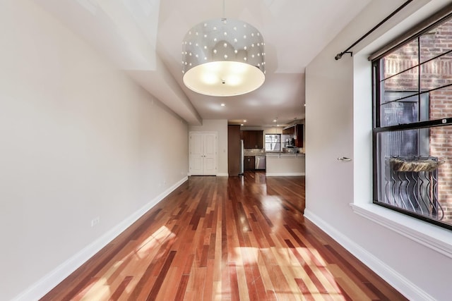 hallway featuring dark wood-style floors and baseboards
