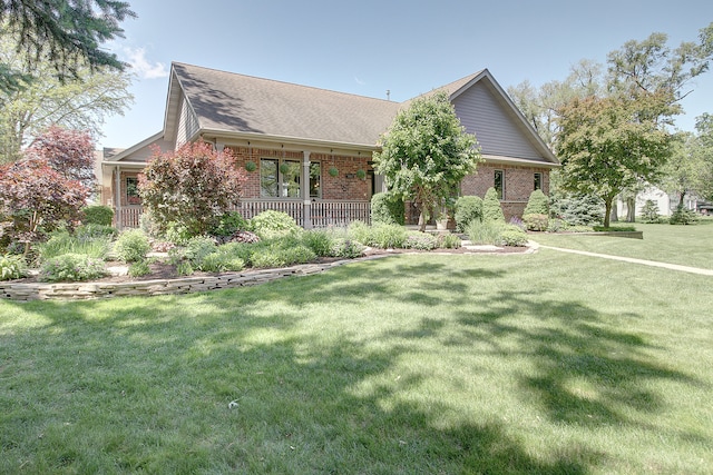 2601 Commonwealth Ave, Joliet, IL 60435 - view of front facade with brick siding, a front lawn, roof with shingles, and a porch