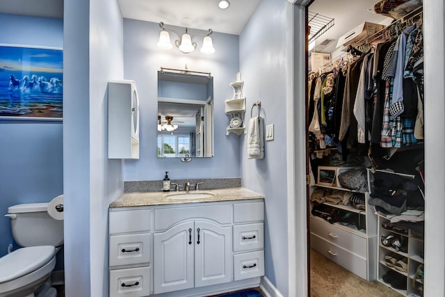 13228 S Westview Dr Unit 2A, Palos Heights, IL 60463 - bathroom with vanity, toilet, a walk in closet, a ceiling fan, and baseboards