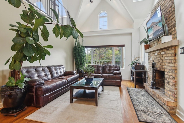89 Huron St, Maywood, IL 60153 - living room with wood finished floors, high vaulted ceiling, a brick fireplace, and baseboards