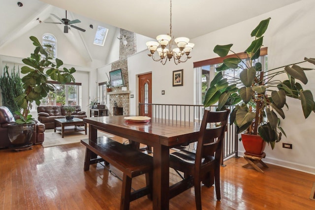 89 Huron St, Maywood, IL 60153 - dining area featuring a ceiling fan, a skylight, hardwood / wood-style flooring, high vaulted ceiling, and a brick fireplace