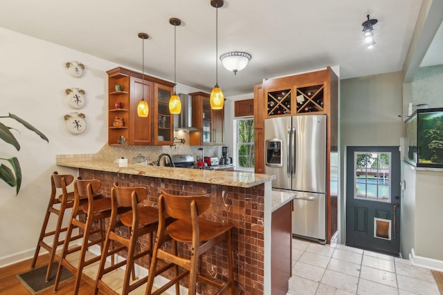 89 Huron St, Maywood, IL 60153 - kitchen featuring appliances with stainless steel finishes, a peninsula, backsplash, light stone counters, and plenty of natural light