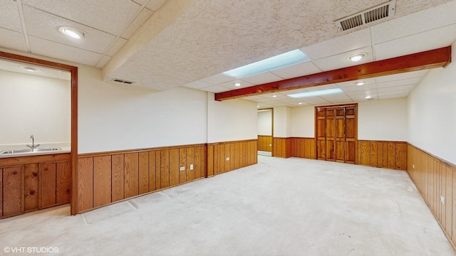 315 Carmelhead Ln, Schaumburg, IL 60193 - carpeted empty room with a wainscoted wall, a sink, a paneled ceiling, and wooden walls