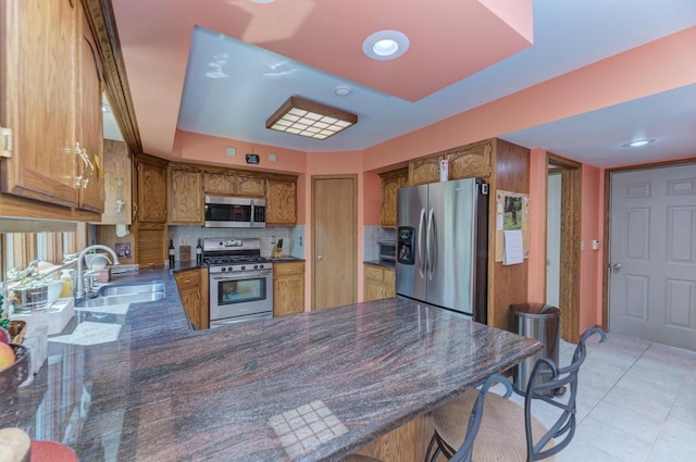32911 Deer Ridge Dr, Wilmington, IL 60481 - kitchen with stainless steel appliances, a sink, brown cabinets, a peninsula, and decorative backsplash