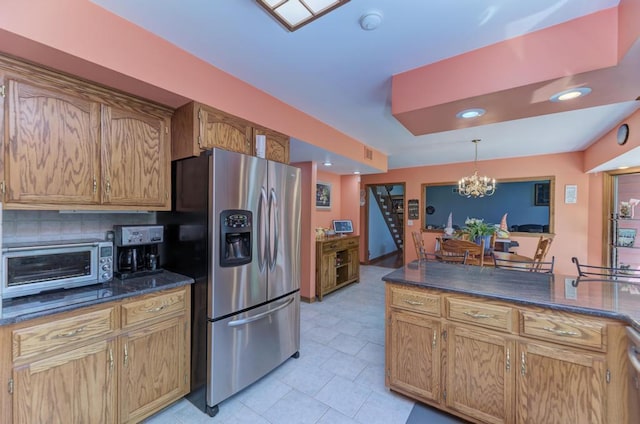 32911 Deer Ridge Dr, Wilmington, IL 60481 - kitchen with stainless steel fridge, a chandelier, pendant lighting, brown cabinets, and tasteful backsplash