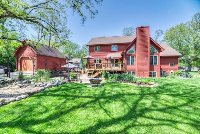 32911 Deer Ridge Dr, Wilmington, IL 60481 - rear view of house featuring a fire pit, a chimney, a deck, an outbuilding, and a garage