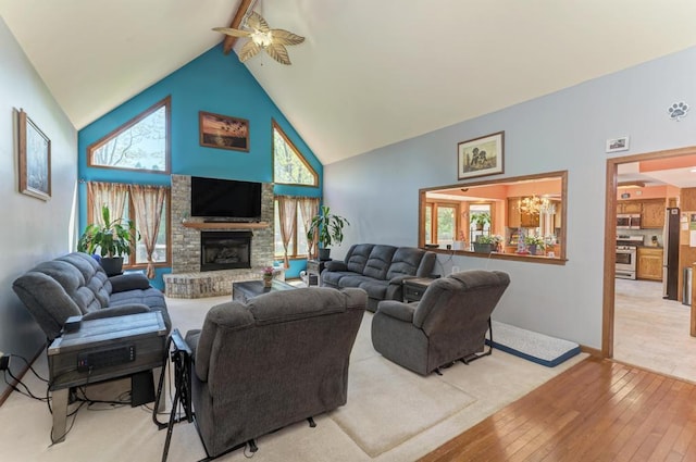 32911 Deer Ridge Dr, Wilmington, IL 60481 - living area with light wood finished floors, high vaulted ceiling, ceiling fan, a fireplace with raised hearth, and beamed ceiling