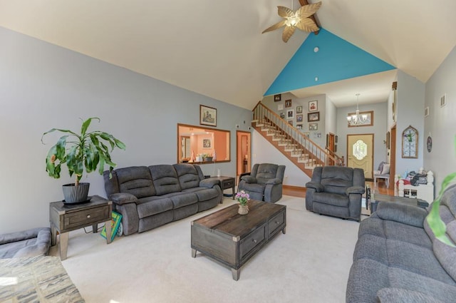 32911 Deer Ridge Dr, Wilmington, IL 60481 - living area with high vaulted ceiling, stairs, a chandelier, a ceiling fan, and light carpet