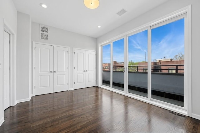 1018 N Honore Ave Unit C, Chicago, IL 60622 - unfurnished bedroom featuring access to outside, multiple closets, dark wood-style floors, baseboards, and recessed lighting