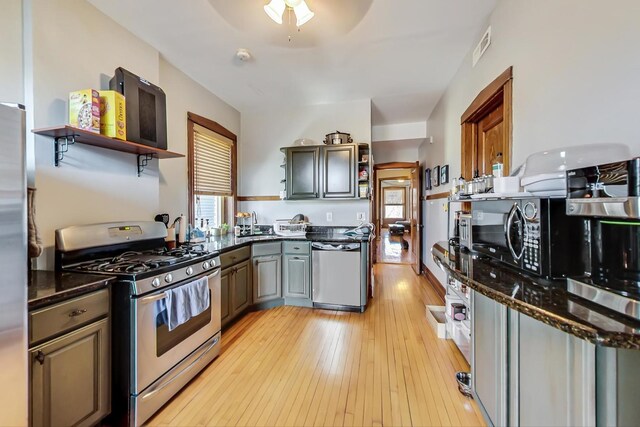3746 N Hermitage Ave, Chicago, IL 60613 - kitchen with appliances with stainless steel finishes, open shelves, light wood-style floors, and dark stone countertops