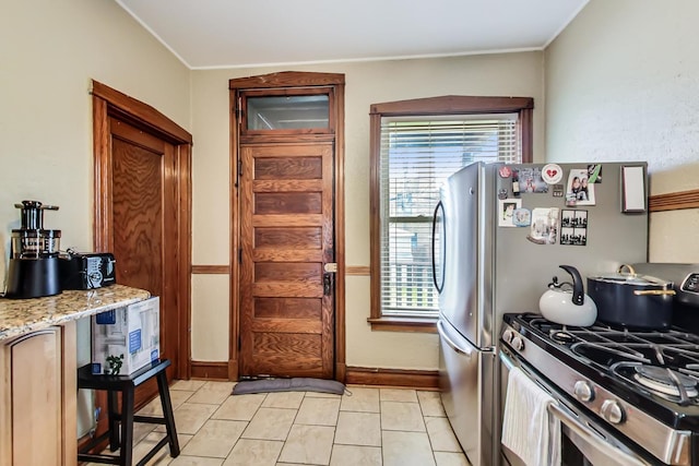 3746 N Hermitage Ave, Chicago, IL 60613 - kitchen with stainless steel gas range, baseboards, ornamental molding, light stone counters, and light tile patterned floors