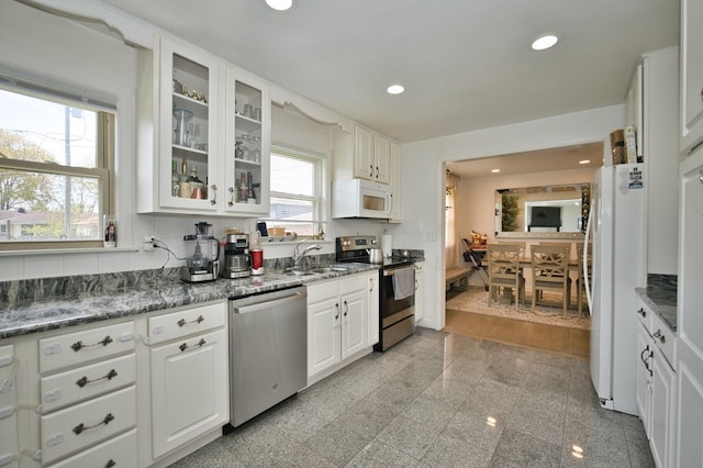 5025 Jerome Ave, Skokie, IL 60077 - kitchen featuring stainless steel appliances, a sink, white cabinets, glass insert cabinets, and granite floors