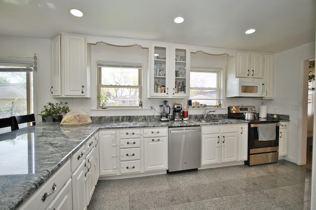5025 Jerome Ave, Skokie, IL 60077 - kitchen featuring stainless steel appliances, a sink, white cabinetry, recessed lighting, and dark stone counters